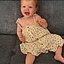 toddler, child, smiling, dress, sitting, couch, hair_clip, barefoot, happy, cute, indoors, person, young_child, casual, relaxed, face, skin, buttoned_dress, legs, arm