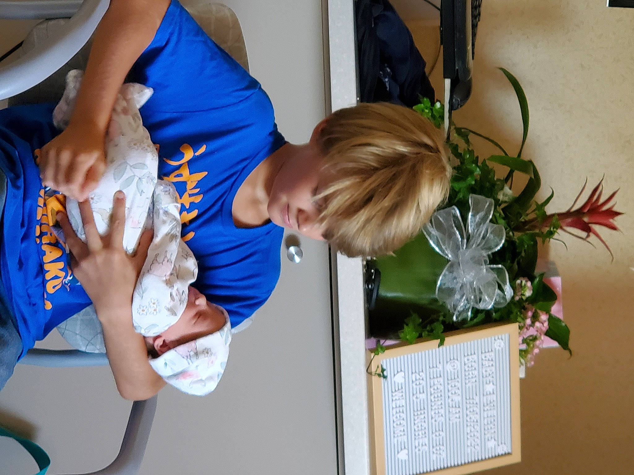 Ash is registered to the contest to win money with this photo: arm, artificial_flower, child, elbow, electric_blue, event, floral_design, flower_arranging, flowerpot, fun, gesture, houseplant, leisure, person, plant, room, shorts, t_shirt, toddler, tree