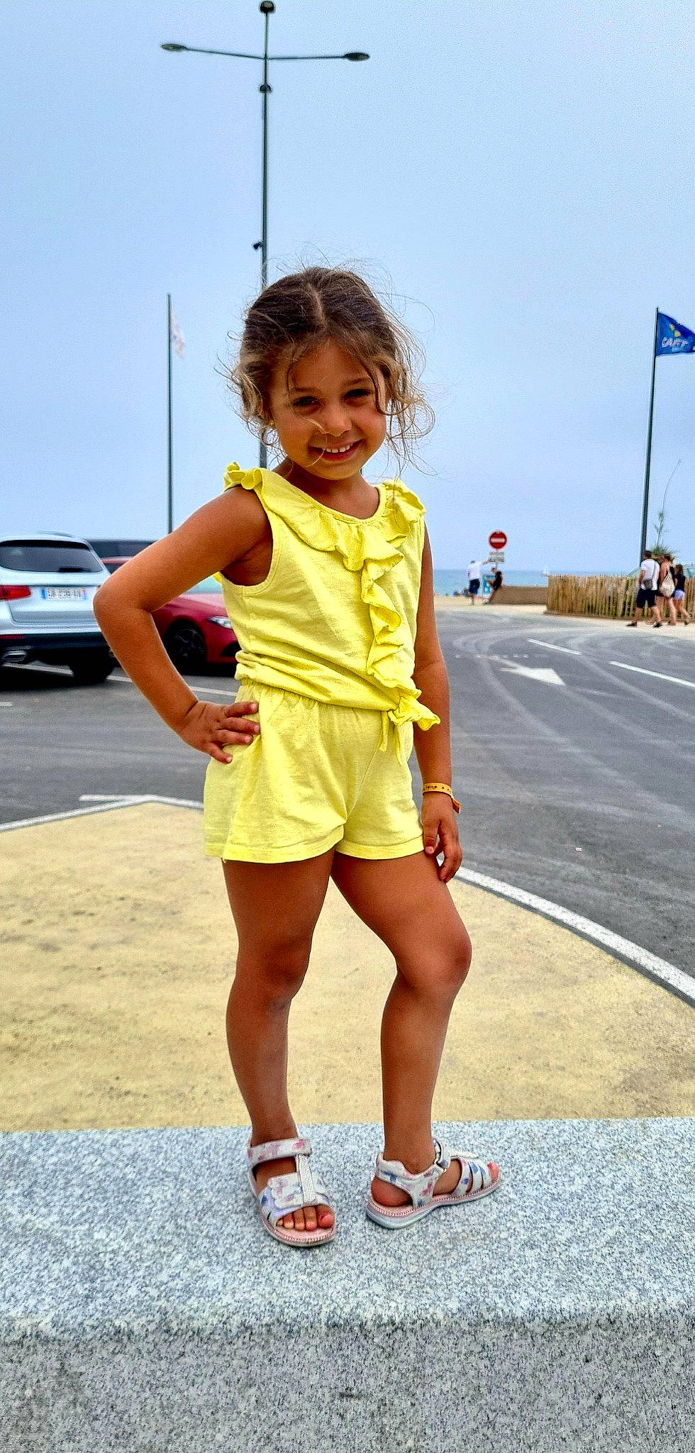 élise participe au concours pour gagner de l'argent avec cette photo : asphalt, blond, car, dress, electric_blue, fashion_design, hair, happy, human_leg, joy, knee, leg, person, recreation, road, sandal, shoe, sky, smile, street_fashion