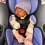 baby, newborn, car_seat, sleeping, hat, pink_socks, safety_harness, infant_clothing, purple_padding, child, cute, peaceful, resting, indoors, soft_textile, newborn_hat, baby_girl, baby_accessory, seat_belt, child_safety