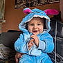 Gabriel participe au concours pour gagner de l'argent avec cette photo : baby, blanket, blue_onesie, casual_clothing, child, clapping, couch, cozy, face, hand, happy, home, hood, indoor, monster_costume, parent, person, portrait, seated, smiling