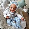 baby, child, smile, baby_swing, clothing, hat, indoor, toy, star, happy, infant, seat, fabric, footwear, person, cute, playful, comfort, strap, floor
