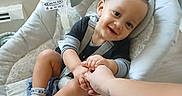 Elijah joined the competition — help win amazing prizes! baby, child, swing, cushion, hand_holding, smile, happy, indoor, person, infant, clothing, sock, toy, comfort, home, seat, tattoo, floor, wall, light