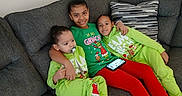 Tyanna joined the competition — help win amazing prizes! child, children, couch, sofa, green_clothing, grinch, pacifier, phone, smile, happy, family, indoors, sitting, red_pants, striped_pillow, casual, relaxed, toddler, siblings, cozy