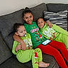casual, child, children, couch, cozy, family, green_clothing, grinch, happy, indoors, pacifier, phone, red_pants, relaxed, siblings, sitting, smile, sofa, striped_pillow, toddler