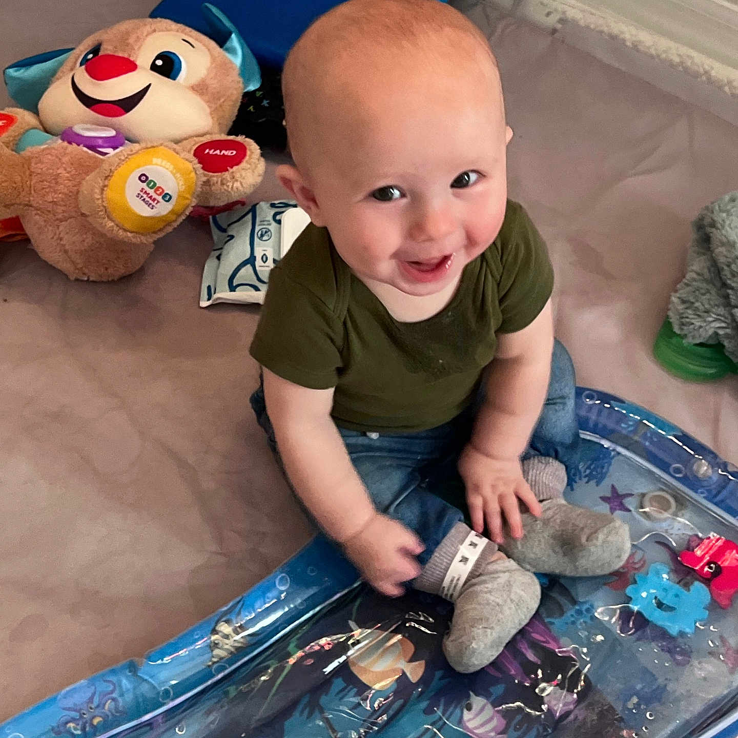 Connor Tolkien is registered to the contest to win money with this photo: baby, clothing, couch, cushion, face, happy, head, homedecor, hosiery, jeans, pants, person, photography, plush, portrait, sitting, smile, sock, t_shirt, toy