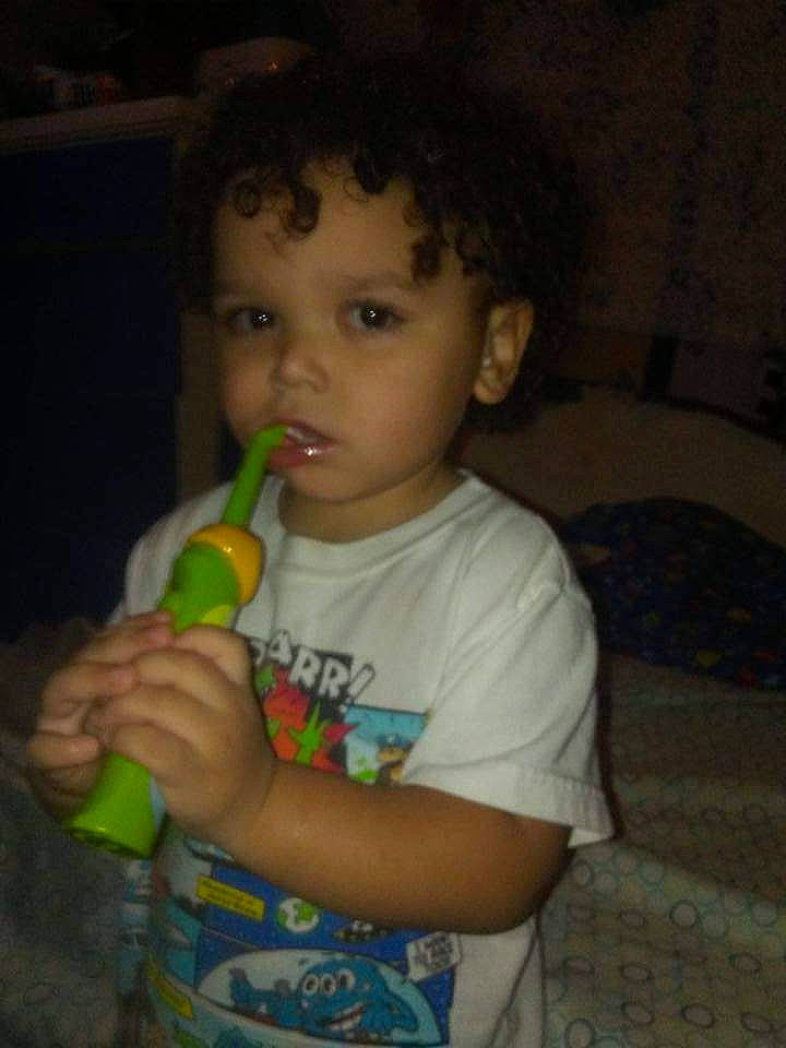 Timothy is registered to the contest to win money with this photo: baby, cheek, child, couch, drinkware, fun, gesture, happy, iris, mouth, nose, person, room, t_shirt, thumb, toddler