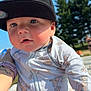 baby, child, cap, hat, onesie, cartoon, lion, outdoor, sunlight, sky, trees, tattoo, watch, arm, closeup, cute, person, infant, summer, portrait