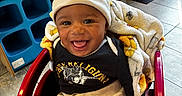 Jayden joined the competition — help win amazing prizes! baby, infant, child, smiling, happy, portrait, shopping_cart, red_cart, blanket, hat, clothing, store, shoe_display, shoes, indoor, retail, restaurant, mcdonalds, seated, close_up