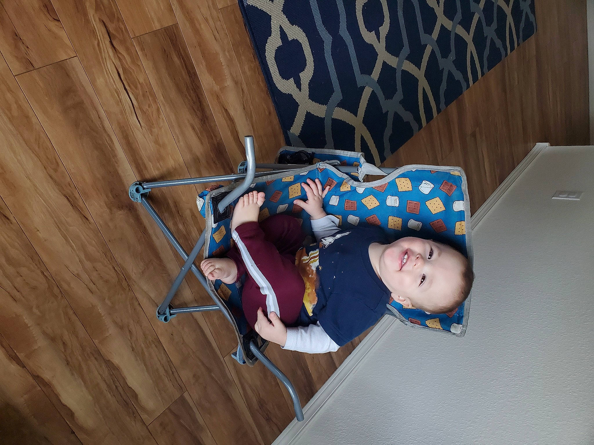 Micheal is registered to the contest to win money with this photo: baby_products, child, electric_blue, flooring, fun, hardwood, joy, leisure, pattern, person, plywood, room, sitting, toddler, tree, wood, wood_flooring, wood_stain