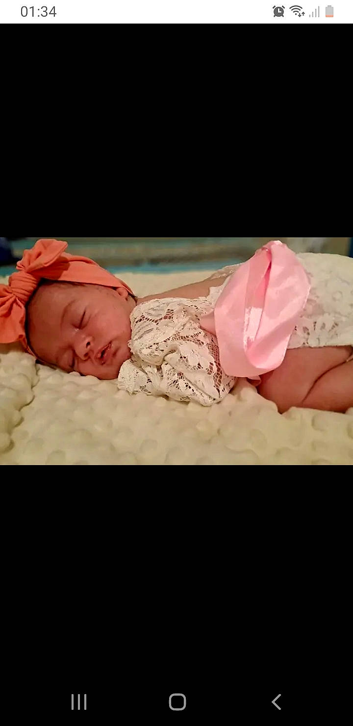 Ylena participe au concours pour gagner de l'argent avec cette photo : arm, baby, baby_sleeping, baby_toddler_clothing, child, comfort, embellishment, eye, flash_photography, hand, head, headgear, human_body, linens, person, petal, pink, skin, sleeve, toddler