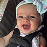 baby, smiling, headband, car_seat, child, infant, happy, cute, hand, clothing, eyes, face, seatbelt, toddler, portrait, blue, fabric, sitting, closeup, indoor