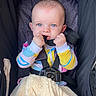 Sofia is registered to the contest to win money with this photo: baby, child, blue_eyes, car_seat, safety_harness, blanket, colorful_clothing, onesie, infant, cute, face, hands, indoor, seat, fabric, soft, comfort, portrait, person, young