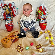 Malo participe au concours pour gagner de l'argent avec cette photo : baby, child, easter, chocolate, kinder, easter_eggs, golden_bunnies, plush_blanket, striped_sweater, sitting, smiling, indoors, festive, holiday, cute, toy_basket, colorful, rosy_cheeks, footwear, portrait