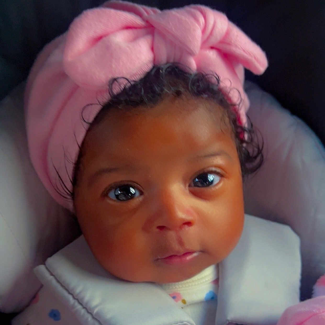 Amily joined the competition — help win amazing prizes! baby, car_seat, child, closeup, clothing, curly_hair, cute, expression, eyes, face, headband, indoors, infant, person, pink, portrait, seatbelt, skin, soft_light, young_child