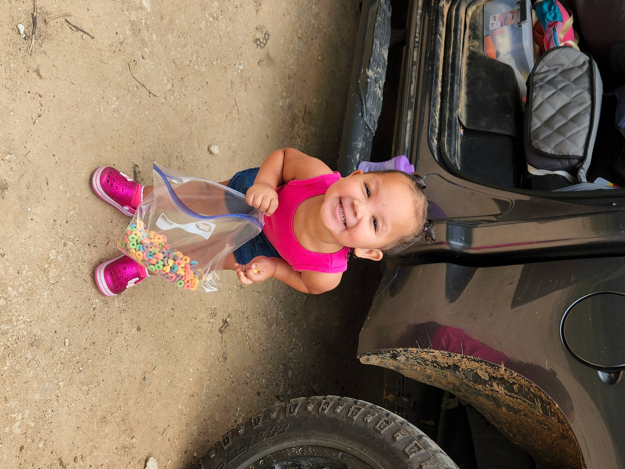 Justice is registered to the contest to win money with this photo: auto_part, automotive_design, automotive_exterior, automotive_tire, bumper, car, dress, fender, fun, joy, leg, motor_vehicle, person, pink, plant, sneakers, tire, toddler, tread, vehicle