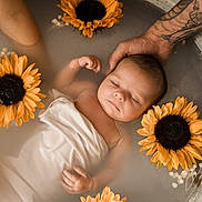 Alba a rejoint le concours — aidez-le/la à gagner de superbes lots ! baby, infant, sleeping, milky_bath, sunflower, flower, tattooed_hand, water, wrapped, peaceful, portrait, relaxation, skin, arm, floral, soft_light, gentle, closeup, baby_bath, serene