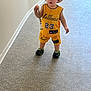 Liam a rejoint le concours — aidez-le/la à gagner de superbes lots ! toddler, child, hat, yellow_clothing, basketball_outfit, indoor, carpet, patterned_floor, pacifier, standing, person, footwear, green_shoes, cute, young_child, hallway, expression, fashion, portrait, casual