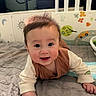 baby, infant, child, smiling, happy, portrait, face, eyes, brown_hair, sitting, lying_down, bed, bedding, crib, nursery, indoors, clothing, long_sleeves, cozy, photography