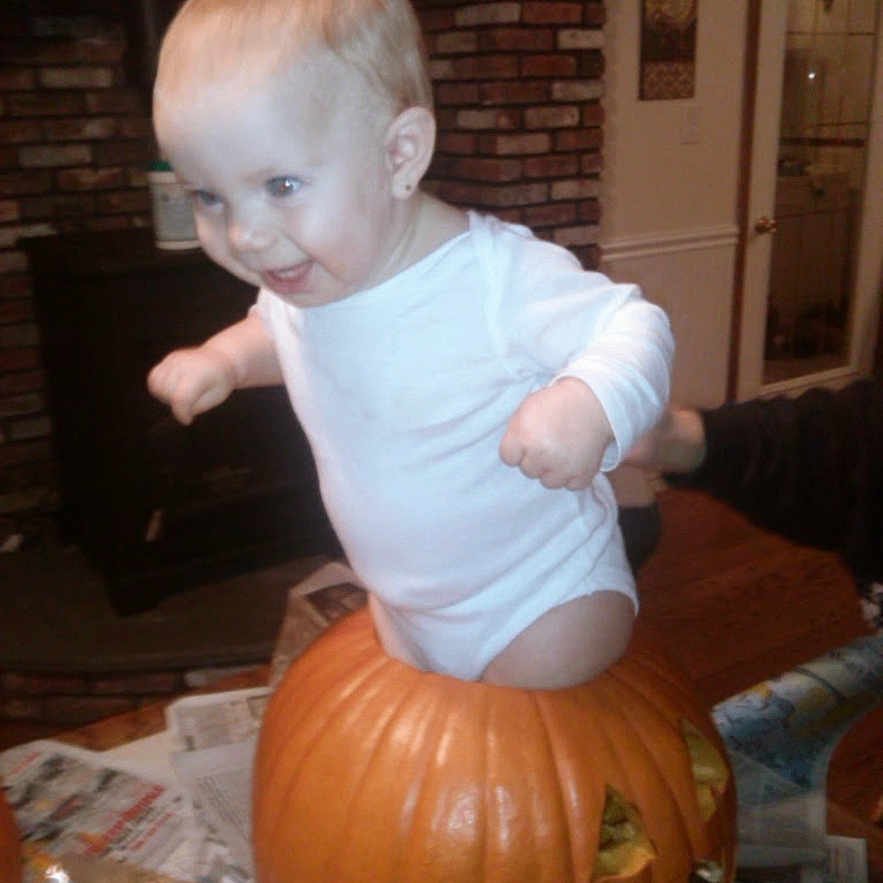 Mackenzie participe au concours pour gagner de l'argent avec cette photo : baby, child, pumpkin, halloween, carved_pumpkin, indoor, onesie, smiling, happy, face, person, hands, floor, newspaper, brick_wall, furniture, door, decor, head, playful