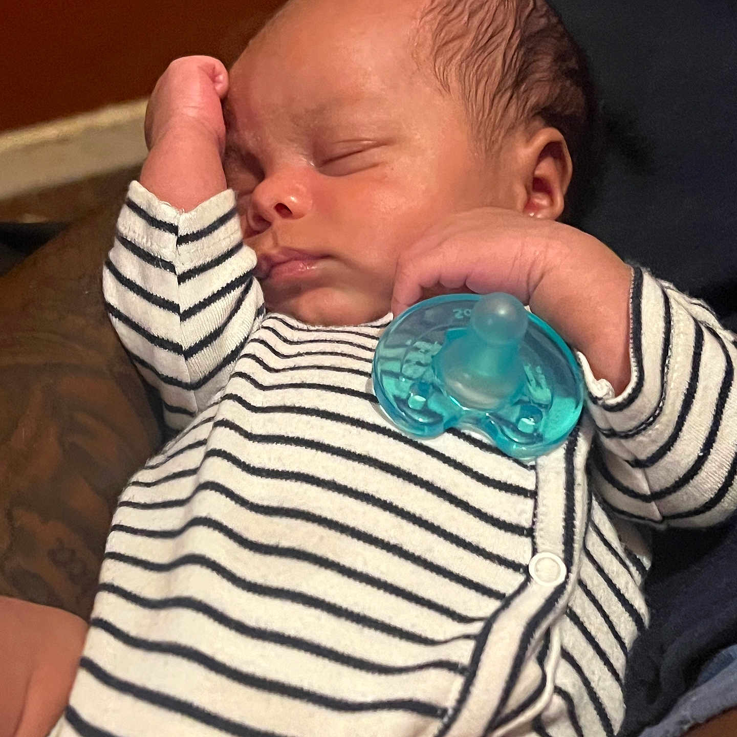 Zaylen is registered to the contest to win money with this photo: baby, sleeping, infant, striped_clothing, pacifier, hand, arm, tattoo, closeup, face, peaceful, resting, skin, newborn, cute, portrait, indoors, comfort, child, person