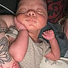Zaylen is registered to the contest to win money with this photo: newborn, baby, sleeping, tattoo, striped_clothing, hand, face, pillow, dinosaur_pattern, arm, infant, resting, closed_eyes, skin, person, cozy, indoor, peaceful, cute, child