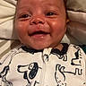 Zaylen is registered to the contest to win money with this photo: baby, smiling, infant, onesie, dog_pattern, face, happy, cute, child, portrait, closeup, sleepwear, lying_down, skin, head, eyes, mouth, indoors, soft, comfort