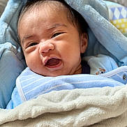 Josh Caleb is registered to the contest to win money with this photo: baby, blanket, blue, pacifier, face, expression, infant, clothing, cute, soft, wrapped, indoors, closeup, newborn, smile, lying_down, nap, baby_bib, child, portrait