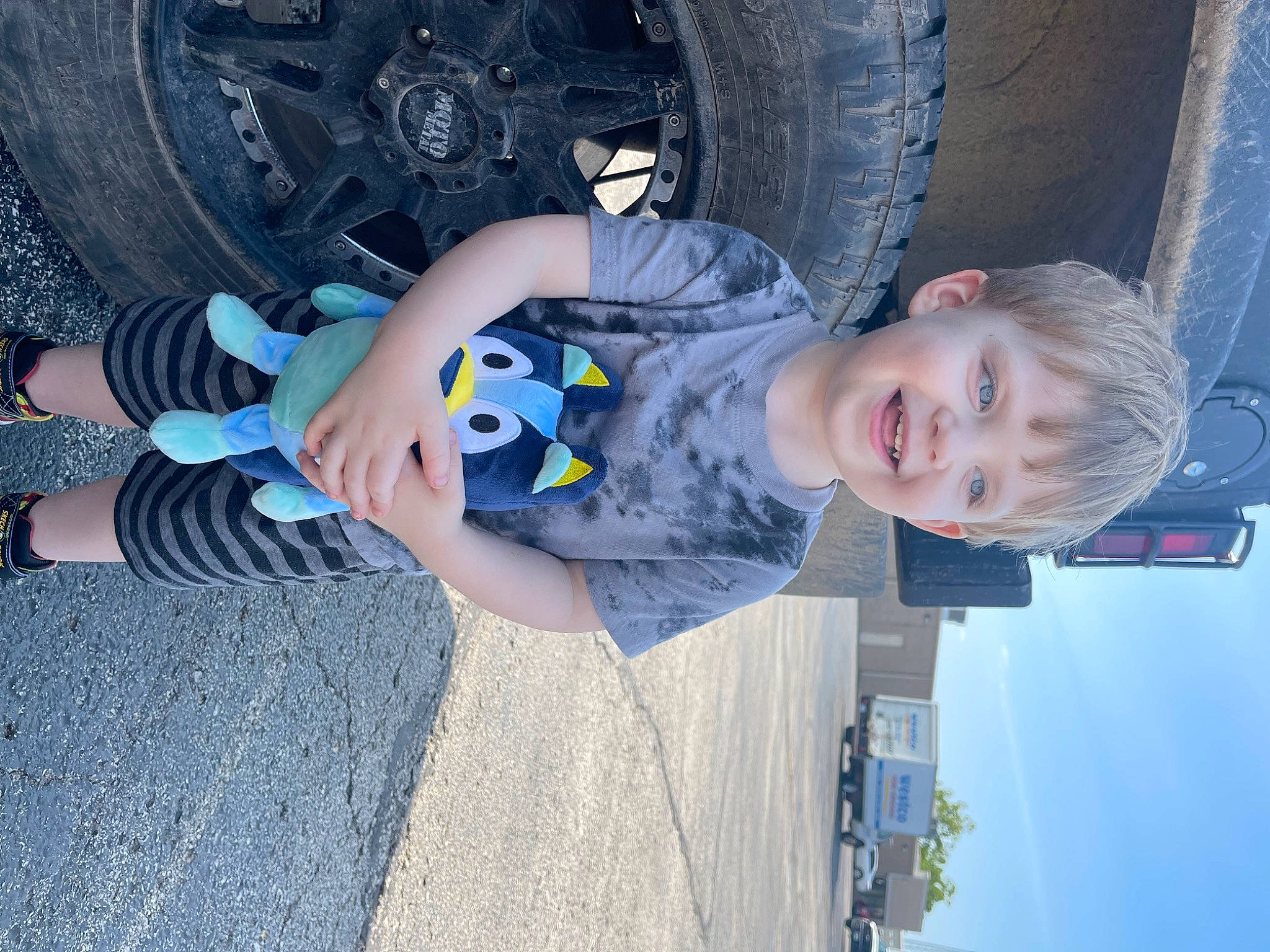 Levi joined the competition — help win amazing prizes! automotive_exterior, automotive_tire, baby_toddler_clothing, blue, child, electric_blue, fender, fun, hubcap, joy, person, rim, sky, smile, synthetic_rubber, tire, toddler, tread, vehicle, vehicle_door