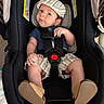 Theo is registered to the contest to win money with this photo: baby, baby_shoes, blue_shirt, car_seat, child, clothing, cute, footwear, hat, indoor, infant, person, portrait, seatbelt, sitting, small_child, smile, striped_shorts, stripes, young