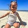 child, toddler, beach, sand, sunny, outdoor, smiling, hair, braids, ocean, sky, summer, clothing, sitting, shadow, cute, portrait, playful, sunlight, happy
