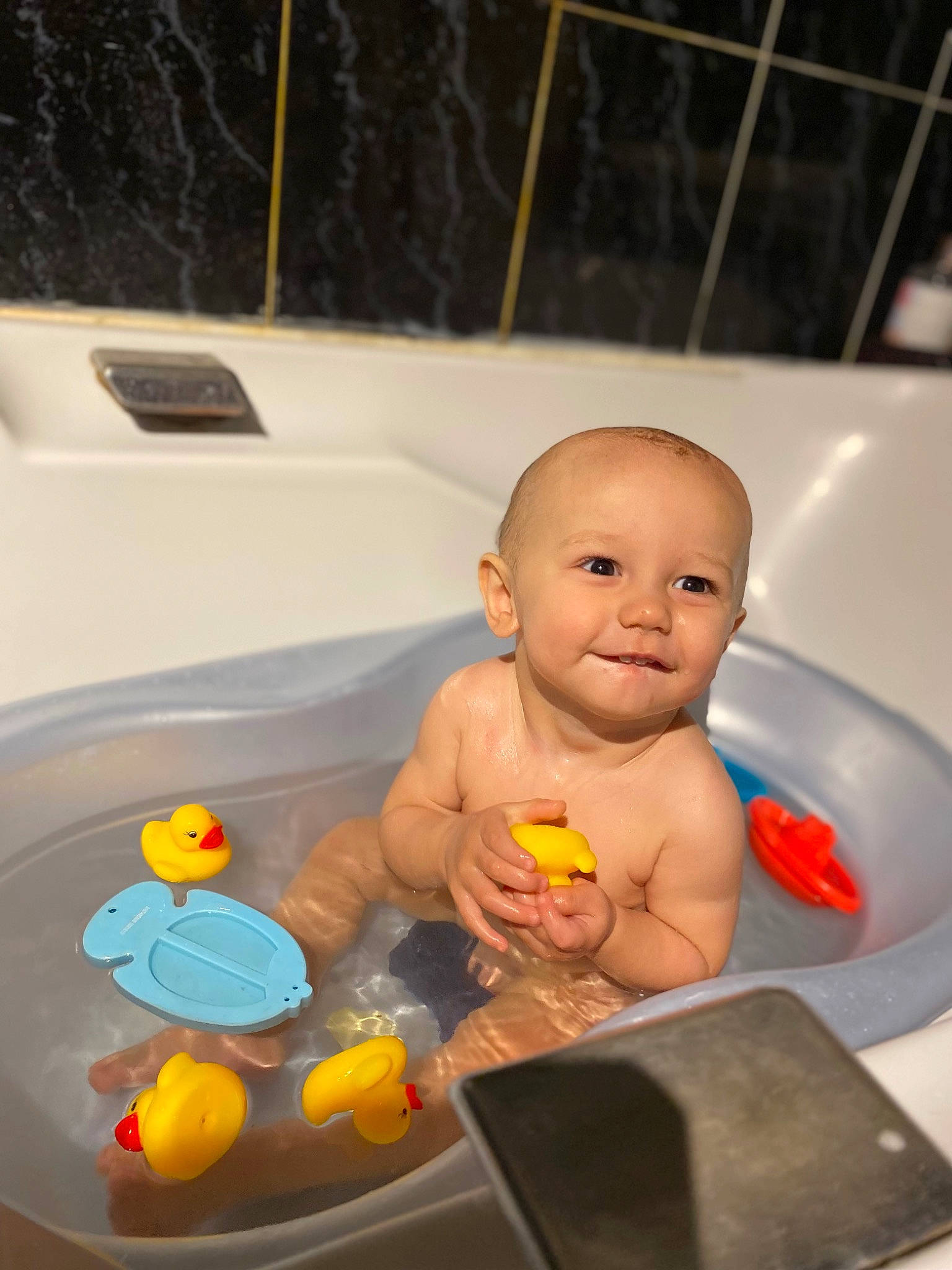 Nino participe au concours pour gagner de l'argent avec cette photo : baby, baby_products, bath_toy, bathing, bathroom, bathtub, child, finger, flooring, fluid, fun, hand, joy, leisure, person, personal_care, plumbing, smile, thumb, toddler