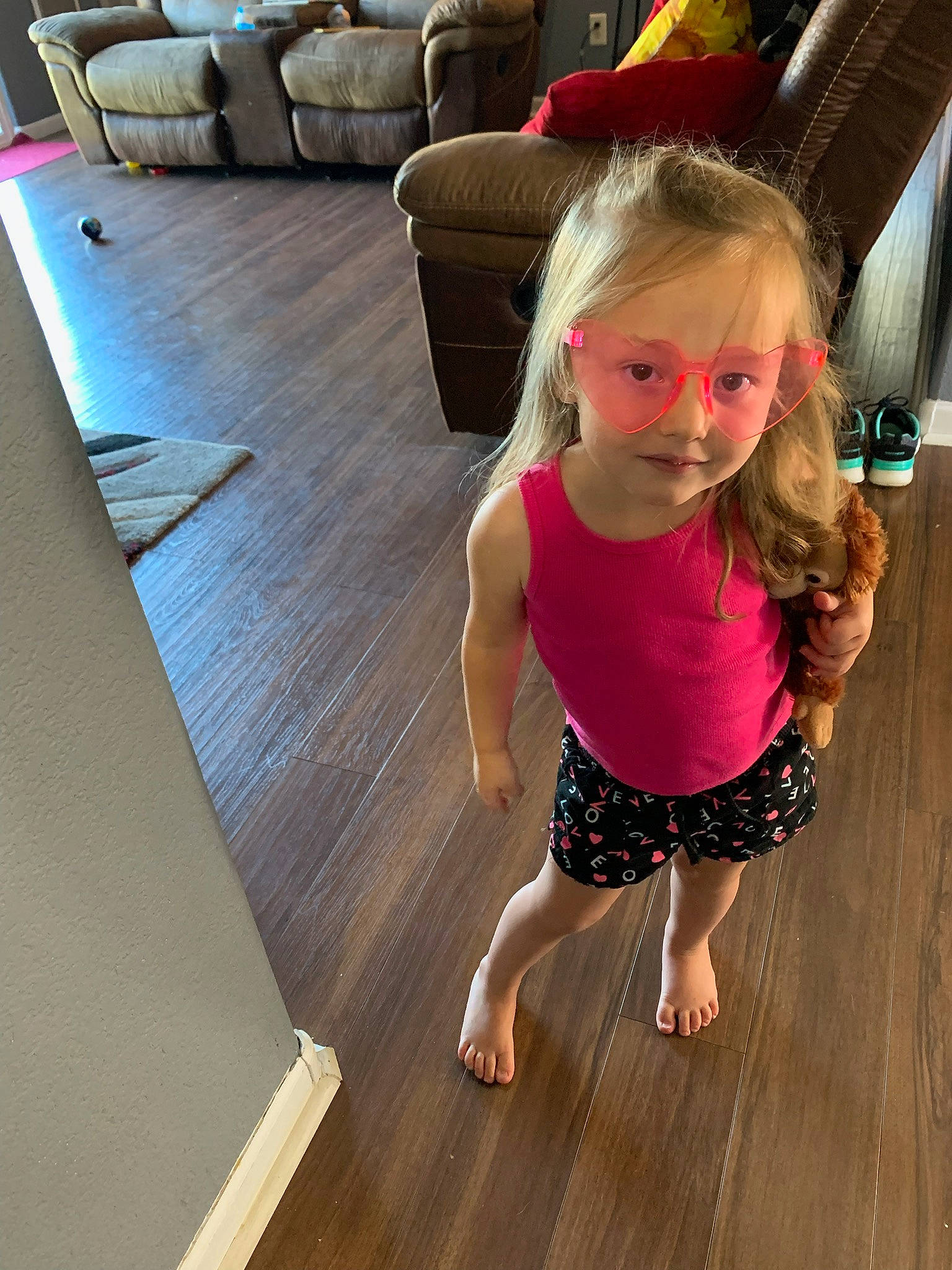 Emersyn is registered to the contest to win money with this photo: barefoot, comfort, couch, floor, flooring, foot, happy, hardwood, human_leg, joint, knee, laminate_flooring, leisure, person, smile, sportswear, thigh, toddler, trunk, waist