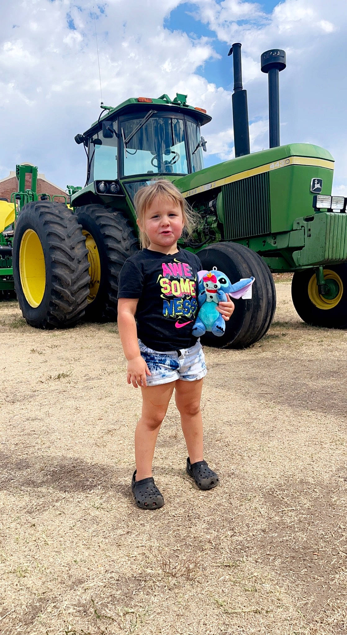 Kensley joined the competition — help win amazing prizes! agricultural_machinery, agriculture, asphalt, automotive_design, automotive_exterior, automotive_tire, automotive_wheel_system, bumper, cloud, grass, green, motor_vehicle, person, rolling, shorts, sky, tire, tractor, tread, vehicle