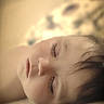 child, sleeping, face, closed_eyes, peaceful, portrait, soft_light, indoors, bed, cozy, young, rest, calm, hair, skin, closeup, serene, relaxation, comfort, quiet