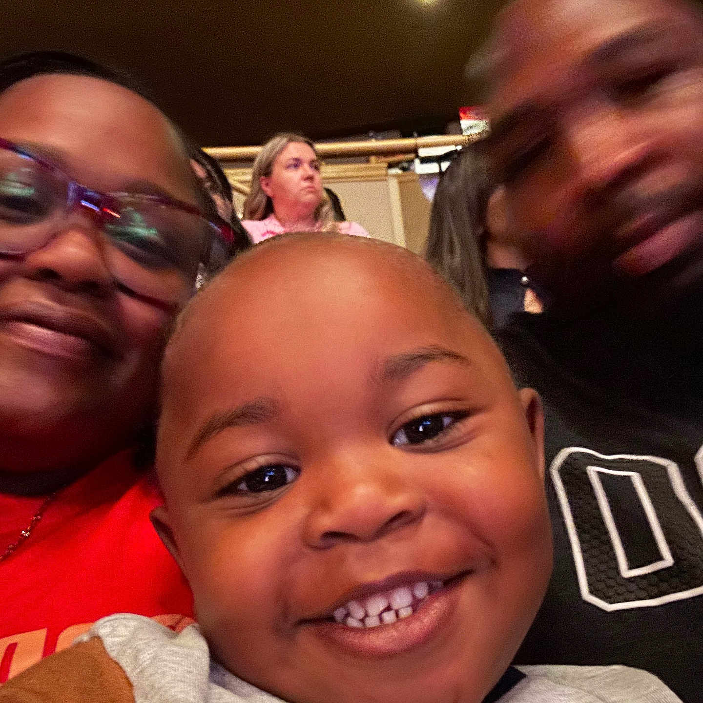 Zavyion is registered to the contest to win money with this photo: adult, blurred, casual_clothing, child, closeup, crowd, diverse, event, expression, family, glasses, happy, headshot, indoor, people, person, portrait, seated, smile, toddler