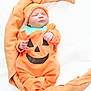 baby, infant, pumpkin_costume, orange, blanket, sleeping, cute, newborn, child, hat, soft, cozy, holiday, halloween, portrait, wrapped, resting, smiling_face, clothing, lying_down