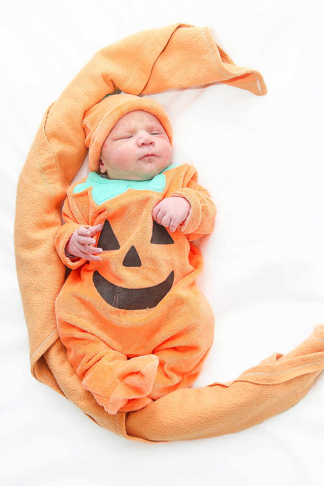 Gabin participe au concours pour gagner de l'argent avec cette photo : baby, infant, pumpkin_costume, orange, blanket, sleeping, cute, newborn, child, hat, soft, cozy, holiday, halloween, portrait, wrapped, resting, smiling_face, clothing, lying_down