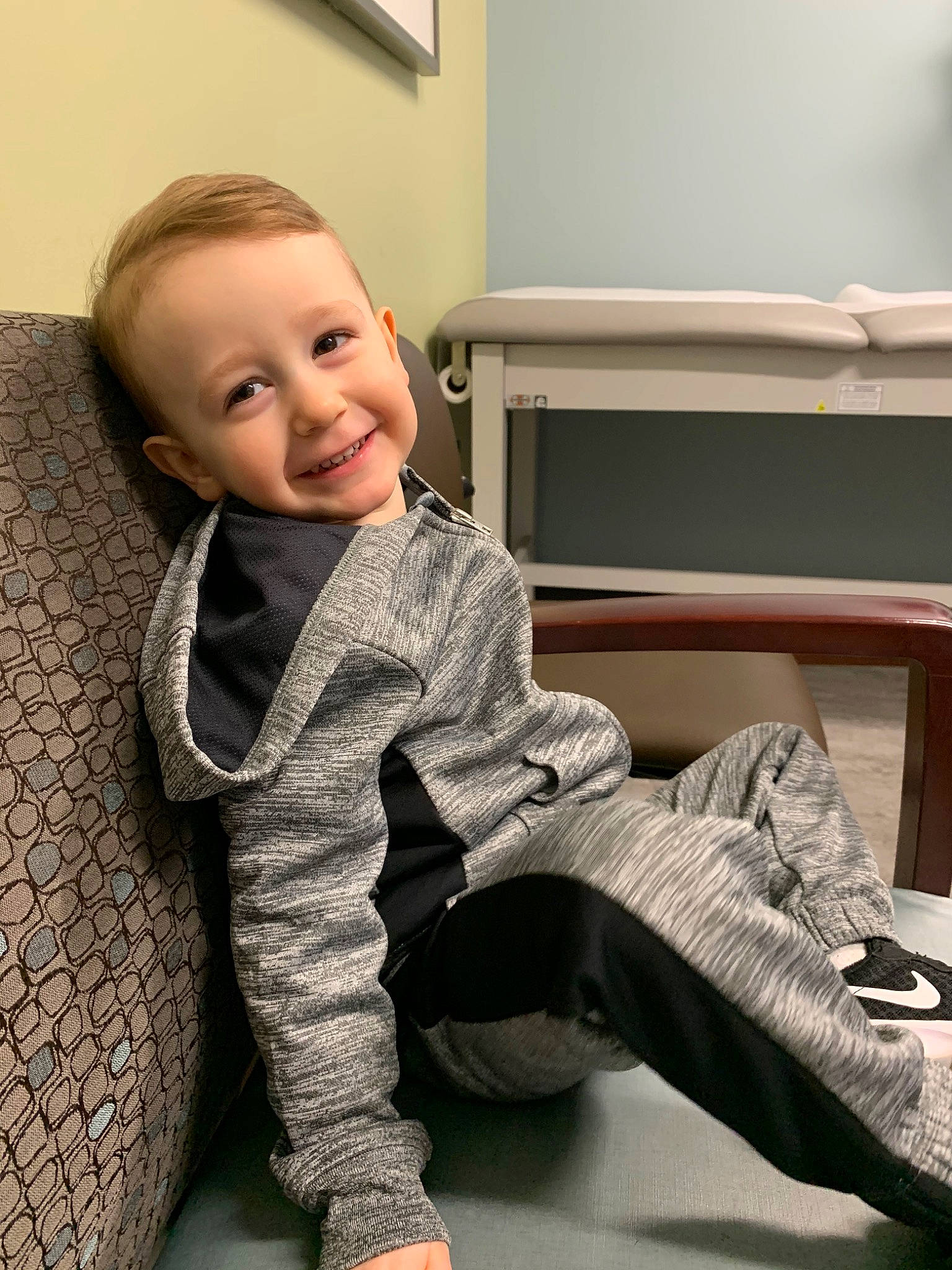 Benton is registered to the contest to win money with this photo: arm, baby, cheek, child, face, joy, leg, nose, outerwear, person, room, sitting, skin, sleeve, smile, toddler