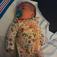 Kylahna joined the competition — help win amazing prizes! baby, newborn, pacifier, floral_onesie, sleeping, blanket, hand, infant, child, bed, soft_lighting, cute, peaceful, indoors, person, small, lying_down, cozy, gentle, resting