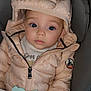 baby, child, puffer_jacket, hood, bunny_ears, teething_toy, blanket, car_seat, blue_eyes, cute, winter_clothing, infant, soft_texture, warm, portrait, indoor, clothing, person, bundle, cozy