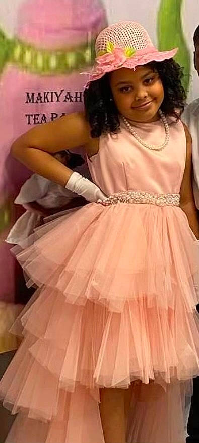 Makiyah is registered to the contest to win money with this photo: bridal_party_dress, day_dress, dress, embellishment, fashion_design, formal_wear, gown, hairstyle, happy, headwear, joy, long_hair, magenta, one_piece_garment, person, pink, ruffle, skin, sleeve, smile