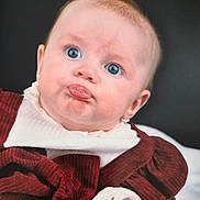 Lily joined the competition — help win amazing prizes! baby, infant, face, blue_eyes, pout, expression, clothing, maroon, white, cute, portrait, child, newborn, soft_lighting, indoors, person, skin, head, hand, background