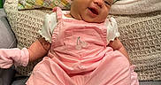 Avalon is registered to the contest to win money with this photo: baby, baby_mittens, baby_socks, child, couch, cute, face, happy, head, indoors, infant, knitted_blanket, patterned_pillow, person, pillow, pink_clothing, portrait, sitting, smiling, white_shirt