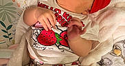 Avalon is registered to the contest to win money with this photo: baby, infant, red_bow, hello_kitty, strawberry, clothing, blanket, patterned_blanket, cute, lying_down, hand, face, headband, soft_texture, cozy, child, indoor, toddler, curious, colorful