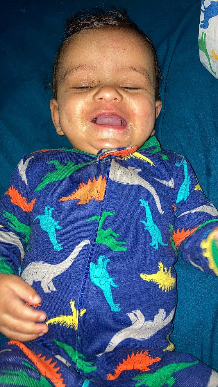 Malcolm is registered to the contest to win money with this photo: baby, baby_toddler_clothing, cheek, child, comfort, cool, electric_blue, finger, forehead, happy, human_body, mouth, neck, nose, organ, person, sleeve, t_shirt, thumb, toddler