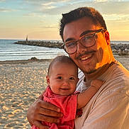 Thaïs a rejoint le concours — aidez-le/la à gagner de superbes lots ! baby, beach, casual_clothing, child, family, glasses, happy, hug, joy, man, nature, ocean, outdoor, portrait, sand, smile, sunlight, sunset, towel, warm_light