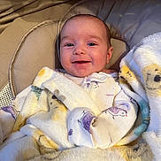 Maelea is registered to the contest to win money with this photo: baby, infant, smiling, blanket, bird_pattern, cushion, soft_texture, cozy, child, face, apparel, sleepwear, happy, portrait, indoor, comfort, newborn, closeup, resting, cute