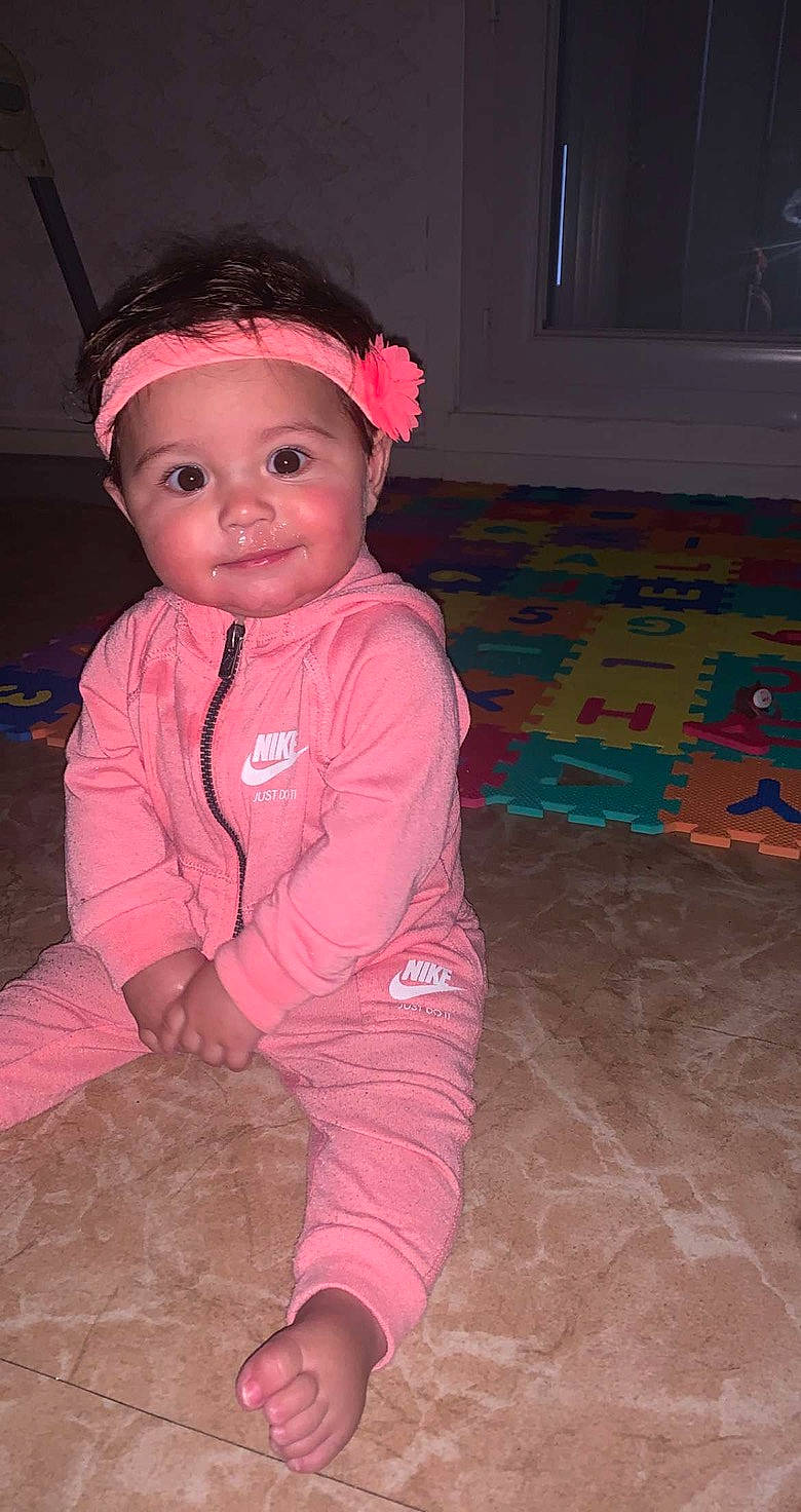 Zina participe au concours pour gagner de l'argent avec cette photo : baby, baby_toddler_clothing, carmine, cheek, child, eye, flash_photography, floor, flooring, fun, happy, hardwood, joy, magenta, pattern, person, pink, sitting, skin, sleeve