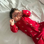 Mia joined the competition — help win amazing prizes! baby, infant, red_onesie, candy_cane_pattern, white_bed, curly_hair, raised_hands, sleepwear, cute, child, lying_down, indoors, soft_light, peaceful, portrait, small_hands, face, cozy, holiday_theme, nap_time
